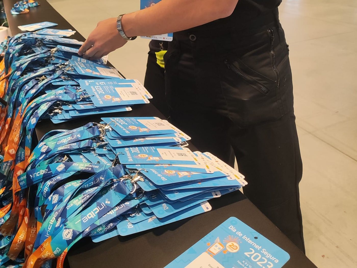 Mostrador con las acreditaciones y los lanyards preparados antes de abrir